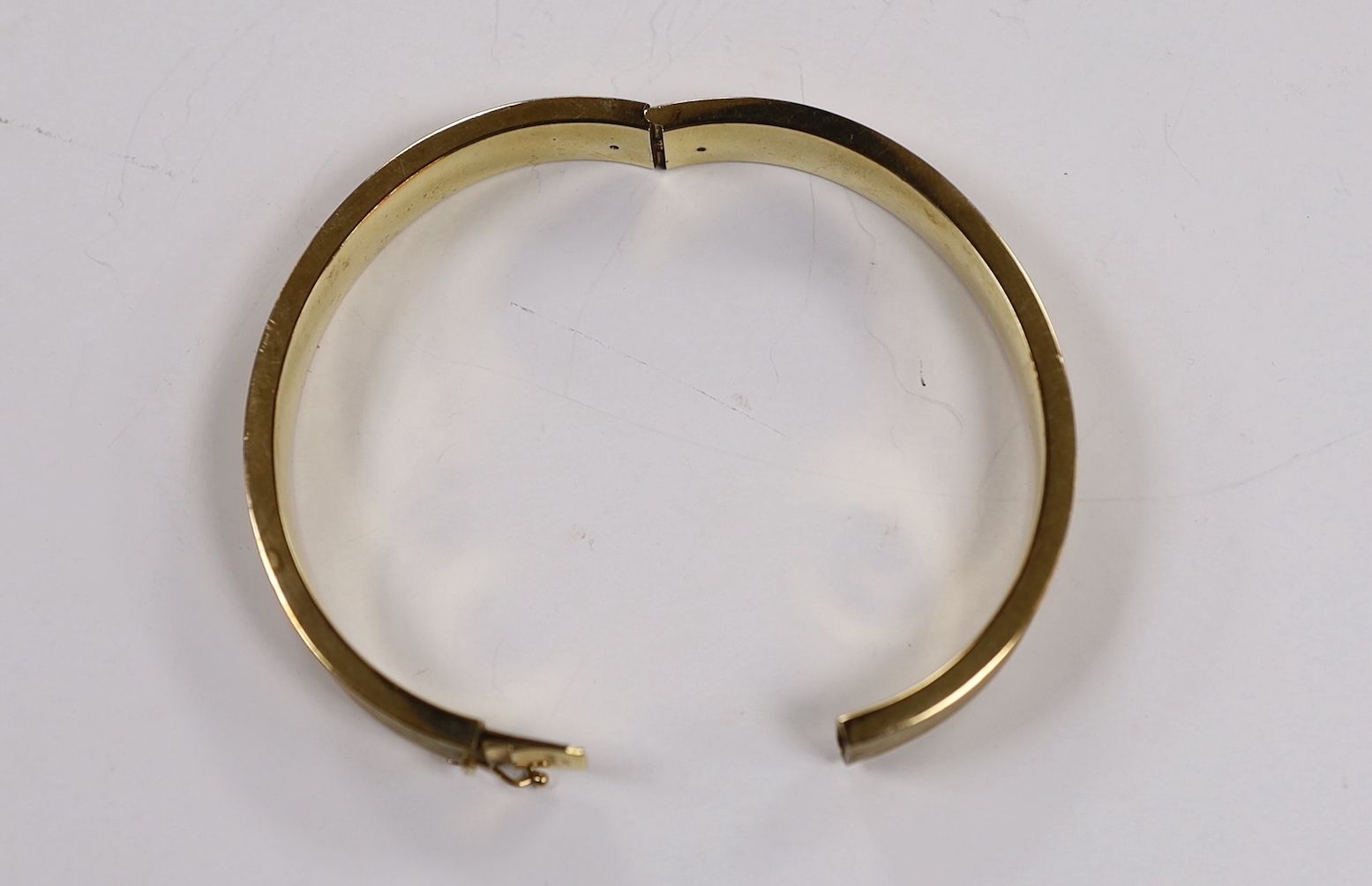 A brushed 9ct gold hinged bangle, interior diameter 63mm, 28.5 grams.